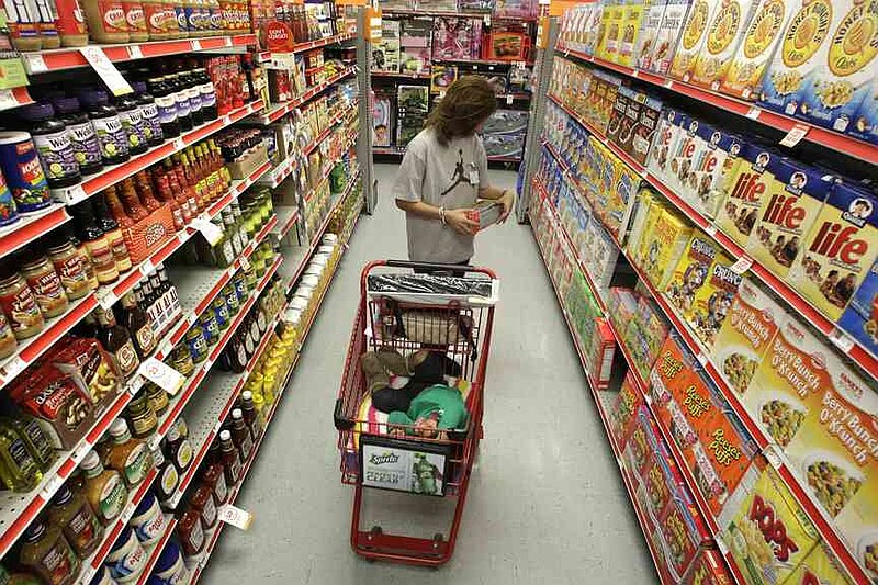A woman looks at products in the aisle of a store as her daughter naps in the shopping cart in Waco, Texas, on Dec. 14, 2010.
