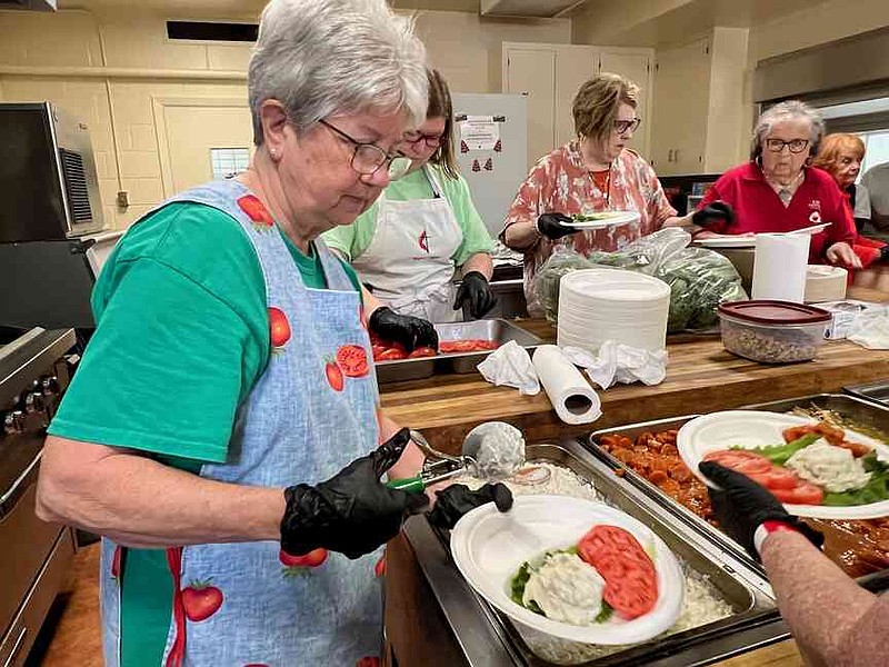 Extension Homemakers Club member Wanda Carr scoops chicken salad onto plates to be served at the All-Tomato Luncheon June 14 at First United Methodist Church in Warren. (Special to The Commercial/University of Arkansas System Division of Agriculture)