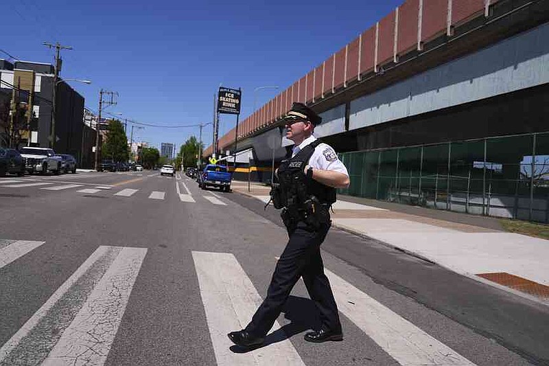 Philadelphia police captain Louis Higginson crosses a street after placing advisory flyers on automobiles, on April 28, 2025, in Philadelphia. (AP Photo/Matt Slocum)