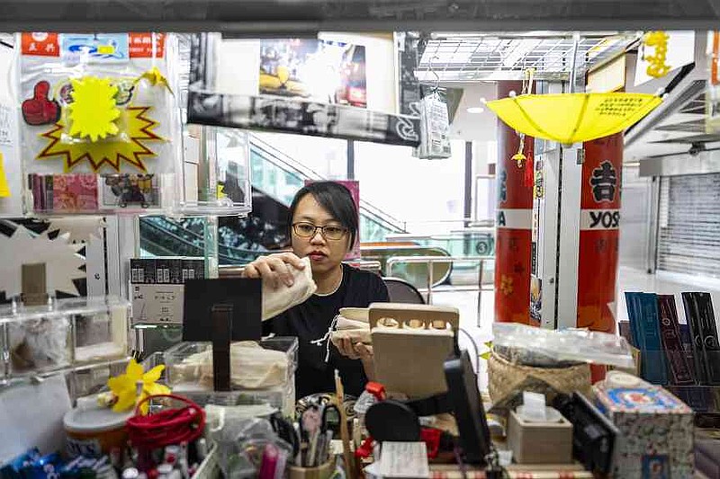 Chan Kim Kam, former pro-democracy district councillor, works at her stall selling incense and essential oils in Hong Kong, Friday, June 20, 2025. (AP Photo/Chan Long Hei)
