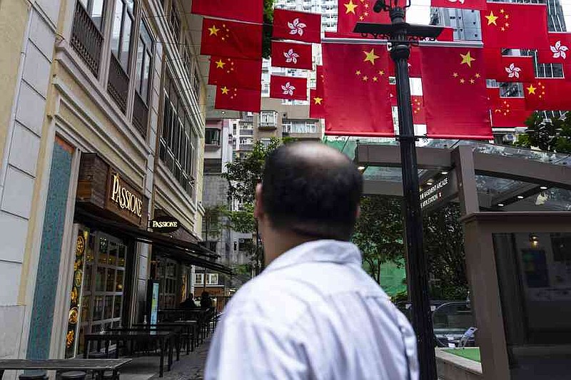 Chinese and Hong Kong SAR flags are hung outside restaurants in Hong Kong, Thursday, June 26, 2025. (AP Photo/Chan Long Hei)