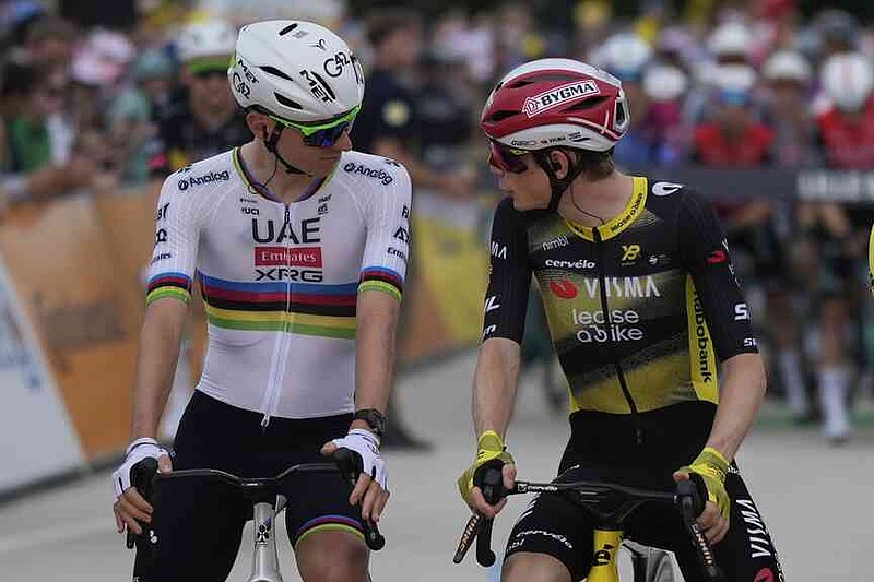 Slovenia's Tadej Pogacar, left, speaks with Denmark's Jonas Vingegaard at the start of the first stage of the Tour de France cycling race over 184.9 kilometers (114.9 miles) with start and finish in Lille, France, Saturday, July 5, 2025. (AP Photo/Mosa'ab Elshamy)