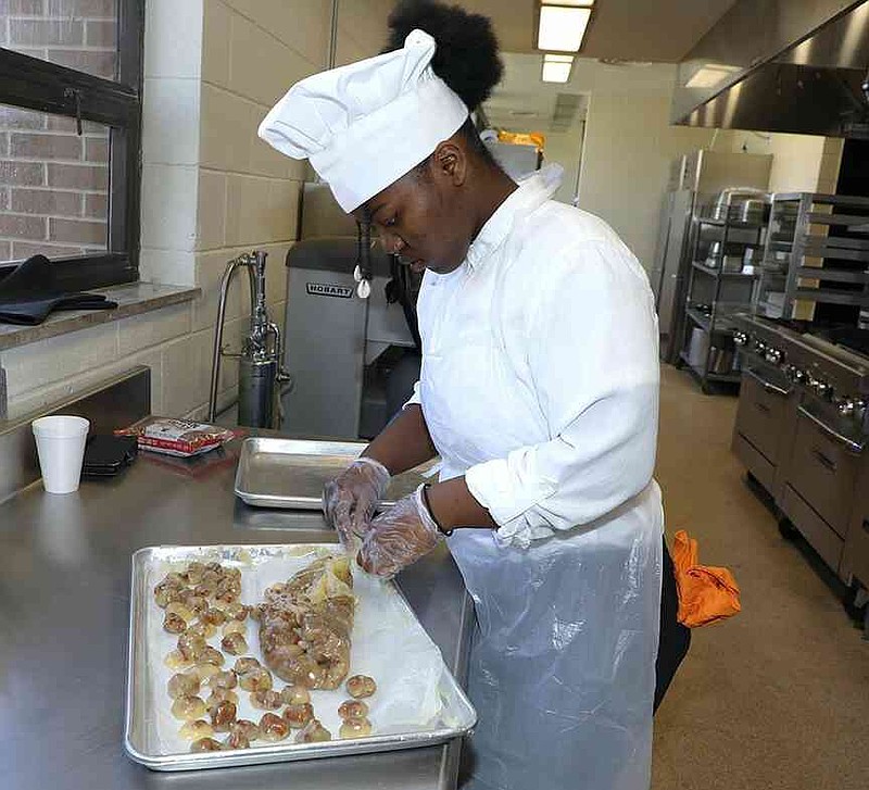 Maria Bradley, a recent graduate of UAPB's hospitality and tourism management program, is shown preparing a dish. (Special to The Commercial/University of Arkansas at Pine Bluff)