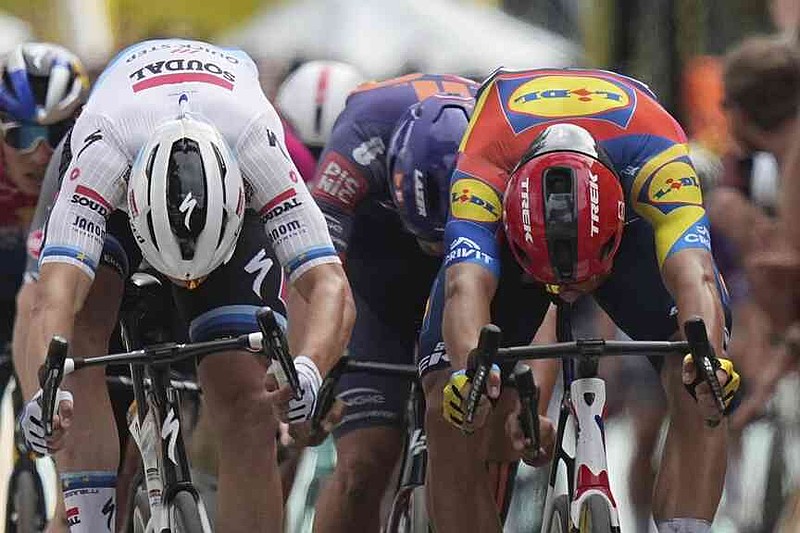 Belgium's Tim Merlier, left, and Italy's Jonathan Milan cross the finish line during the third stage of the Tour de France cycling race over 178.3 kilometers (110.8 miles) with start in Valenciennes and finish in Dunkerque, France, Monday, July 7, 2025. (AP Photo/Thibault Camus)