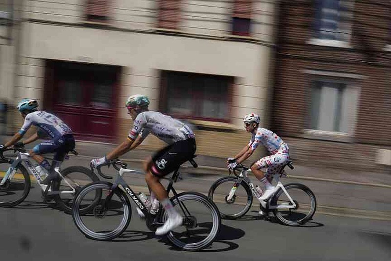 Slovenia's Tadej Pogacar wearing the best climber's dotted jersey, right, rides with Germany's Nils Politt, center, and France's Lenny Martinez during the third stage of the Tour de France cycling race over 178.3 kilometers (110.8 miles) with start in Valenciennes and finish in Dunkerque, France, Monday, July 7, 2025. (AP Photo/Mosa'ab Elshamy)