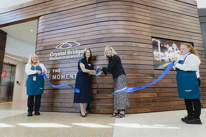 Austen Bailly chief curator of Crystal Bridges and The Momentary, (from left) and Blake Woolsey, XNA board member, cut a ribbon Thursday during a ribbon cutting ceremony for a new Crystal Bridges satellite gallery at the Northwest Arkansas National Airport. Northwest Arkansas National Airport (XNA) and Crystal Bridges Museum of American Art invited press to attend a ribbon cutting ceremony celebrating the opening of the museum's new satellite gallery in the airport terminal. Visit nwaonline.com/photo for today's photo gallery. (NWA Democrat-Gazette/Charlie Kaijo)