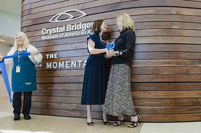 Austen Bailly chief curator of Crystal Bridges and The Momentary, (from left) and Blake Woolsey, XNA board member, cut a ribbon Thursday during a ribbon cutting ceremony for a new Crystal Bridges satellite gallery at the Northwest Arkansas National Airport. Northwest Arkansas National Airport (XNA) and Crystal Bridges Museum of American Art invited press to attend a ribbon cutting ceremony celebrating the opening of the museum's new satellite gallery in the airport terminal. Visit nwaonline.com/photo for today's photo gallery. (NWA Democrat-Gazette/Charlie Kaijo)