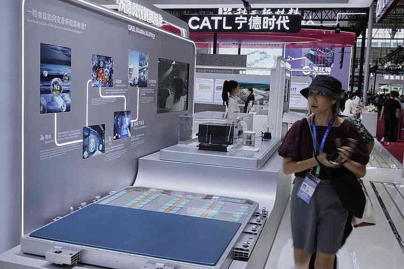 Visitors walk in front of a CATL Naxtra battery is seen at a CATL booth during the 3rd China International Supply Chain Expo at the China International Exhibition Center, in Beijing, China, Friday, July 18, 2025. (AP Photo/Mahesh Kumar A.)