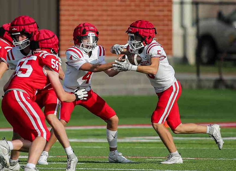 Slade Norwood (4) hands off to Dustin Haffelder (5) during the Farmington spring football game at Cardinal Stadium, Farmington High School, May 23, 2024, Farmington, Arkansas. Norwood then transferred to Greenland and started there last season, then he went to Fayetteville in the offseason before he returned to Farmington. (Special to NWA Democrat-Gazette/Brent Soule)