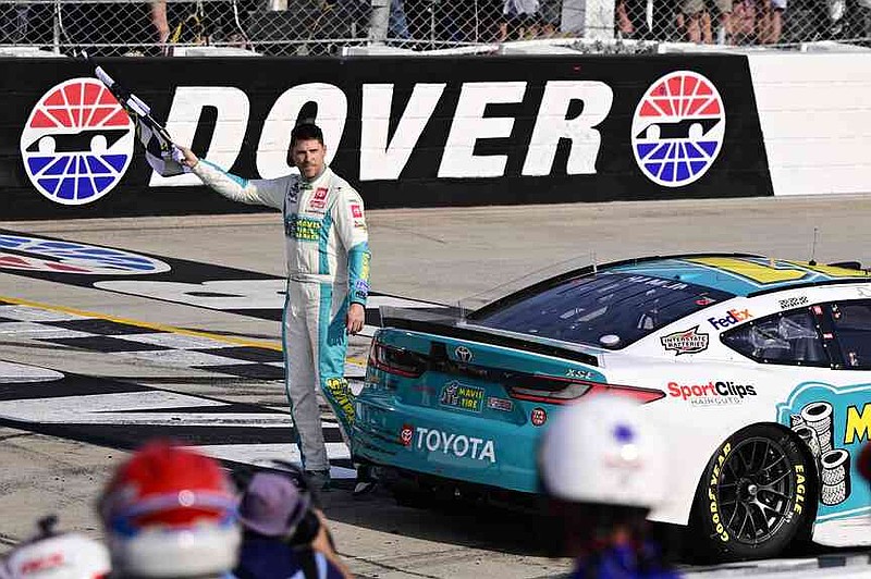 FILE - Denny Hamlin celebrates with the checkered flag after winning a NASCAR Cup Series auto race at Dover Motor Speedway, Sunday, April 28, 2024, in Dover, Del. (AP Photo/Derik Hamilton, File)