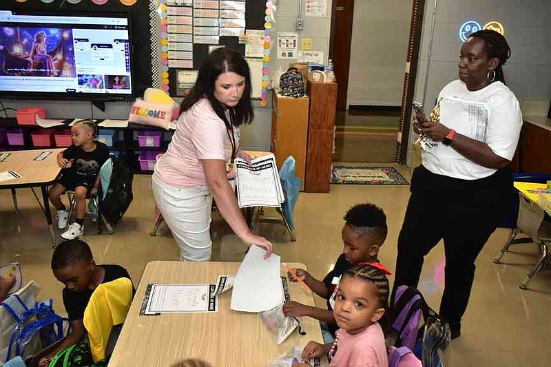 Forrest Park/Greenville Kinder Center teacher Brandy Dutton hands out a writing lesson as principal Marceinia Peoples observes on the first day of class Monday, July 28, 2025. (Pine Bluff Commercial/I.C. Murrell)