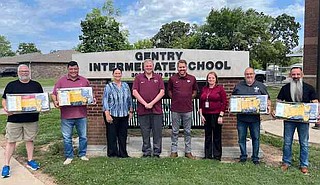 Submitted photo/Gentry School District
Local pastors, carrying school supplies to assist students at the intermediate school, are pictured outside the school with officials from the Gentry School District.