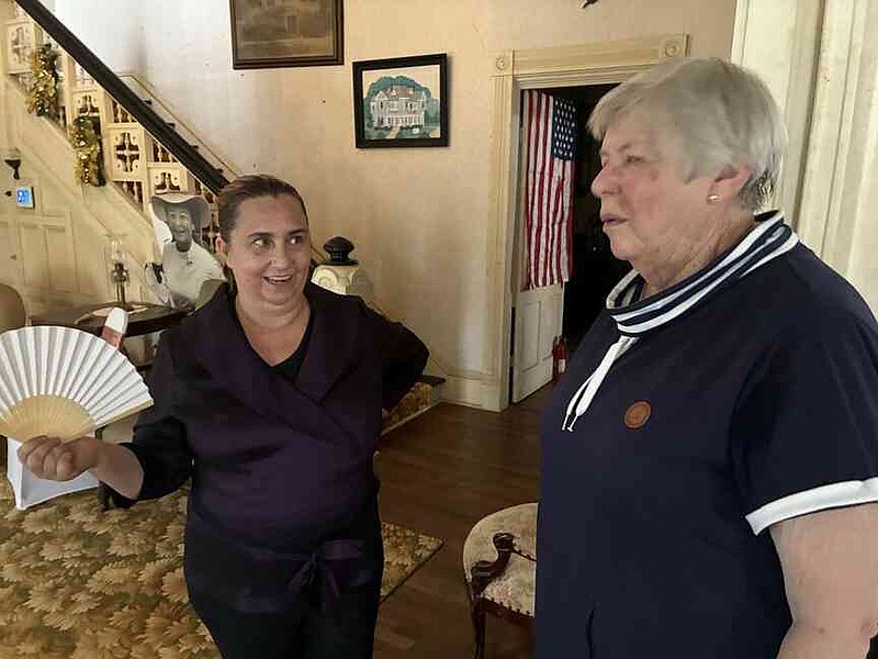 Jennifer Louviere, owner of the Martha Mitchell House (left), talks with Colleen Sandall, a volunteer, share a moment last week at a reception for attendees of the Whistleblower Summit and Film Festival. (Pine Bluff Commercial/Byron Tate)