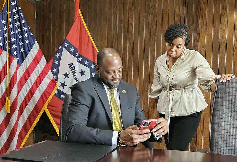 UAPB Chancellor Anthony Graham looks over information from campus spokesperson Stephanie Jackson on Wednesday, July 30, 2025, inside the cabinet meeting room. (Pine Bluff Commercial/I.C. Murrell)