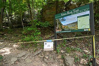 A closure notice is seen July 28 at the trailhead of the Yellow Rock Trail at Devil's Den State Park in West Fork after a double homicide there the previous weekend. There are no security cameras in use anywhere in the park.
(File Photo/NWA Democrat-Gazette/Caleb Grieger)