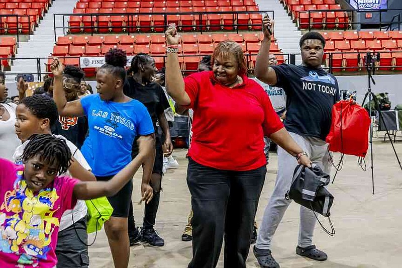 Pine Bluff Councilwoman Yvonne Denton dances with students at Pine Bluff's National Night Out. (Pine Bluff Commercial/Eplunus Colvin)