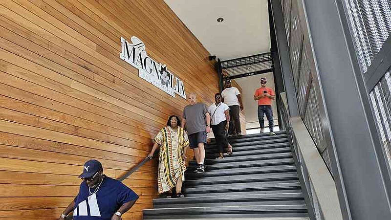 Visitors walk down the stairway from a second-floor patio at The Magnolia Food Market and Bar. (Pine Bluff Commercial/I.C. Murrell)