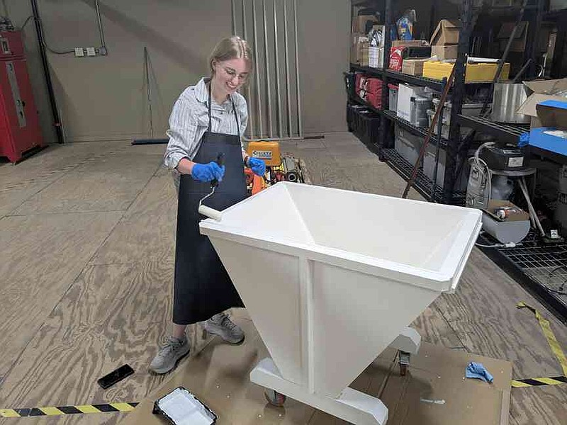 Gwen Keith-Powell, a member of the 2025 Experiential Scholars Program class, paints a large basin as part of her hands-on experiences in the water conservation focus area. (Special to The Commercial/University of Arkansas System Division of Agriculture)