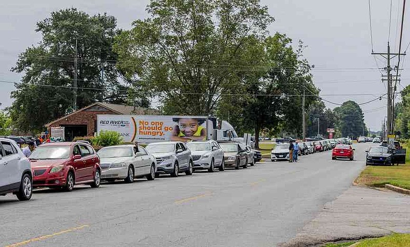 Hundreds line up on Commerce Road in Pine Bluff to receive free food and other essential items during the First Ward Living Grace and Group Violence Intervention citywide giveaway. (Pine Bluff Commercial/Eplunus Colvin)