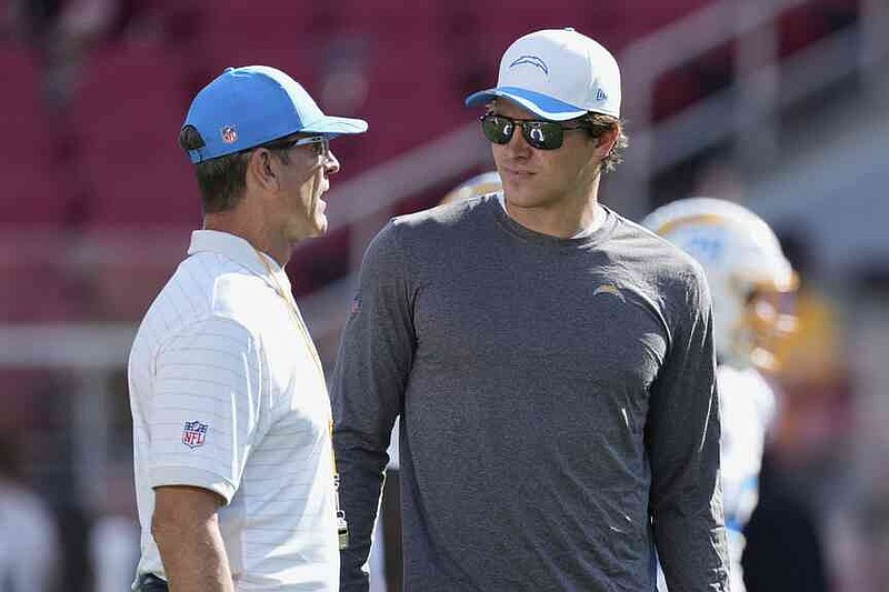 Los Angeles Chargers head coach Jim Harbaugh, left, talks with quarterback Justin Herbert before an NFL preseason football game against the San Francisco 49ers in Santa Clara, Calif., Saturday, Aug. 23, 2025. (AP Photo/Godofredo A. Vásquez)
