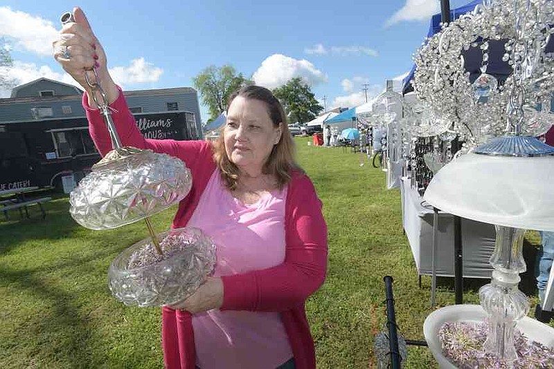 Sharon Hocking of Bentonville shows bird feeders she makes from recycled lamps during spring the Wishing Spring Arts and Crafts Fair behind Wishing Spring Gallery at 8862 W. McNelly Road in Bella Vista. More than 40 vendors will have seasonal gifts, handcrafted goods, art and more for the festival returning Oct. 16-18. Proceeds benefit the Artisan Alliance at Wishing Spring Scholarship. Free admission. (NWA Democrat-Gazette file photo/Flip Putthoff)