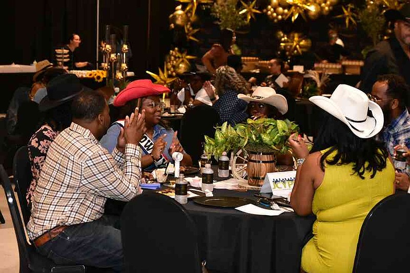 Friends get together, many of them wearing Western hats, in honor of the theme at the Taste of Southeast Arkansas. (Pine Bluff Commercial/I.C. Murrell)