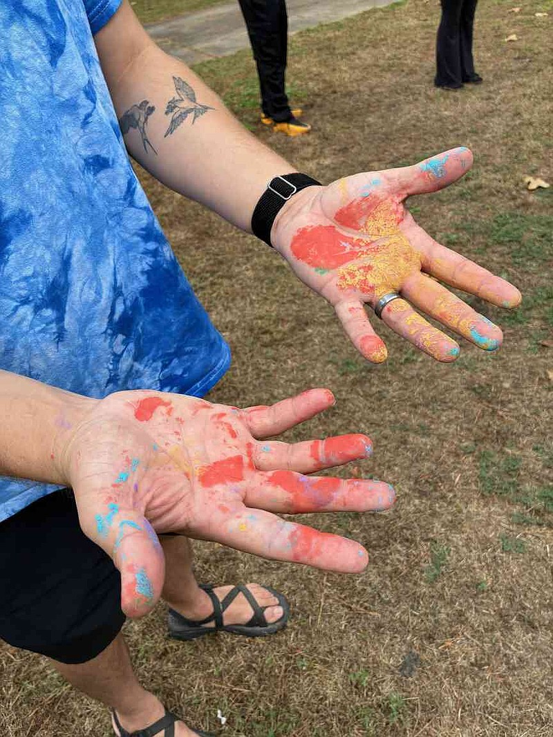 Volunteer Stephen Edwards, a Red Cross employee, admires his hands that indicate he had worked on the "rainbow bridge" being constructed at the Pine Bluff Animal Shelter. (Pine Bluff Commercial/Byron Tate)