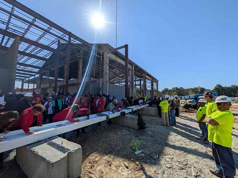 Community members and students sign the final beam to the foundation of the new Pine Bluff High School. (Pine Bluff Commercial/I.C. Murrell)