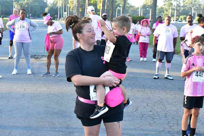Lawson Nooner, 3, graces his mother Autumn with a pink necklace. (Pine Bluff Commercial/I.C. Murrell)