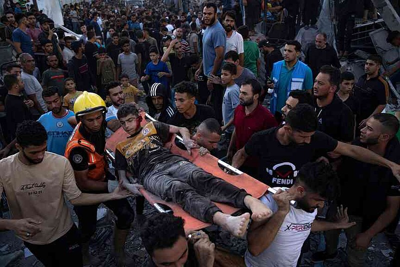 FILE.- Palestinians carry Mohammed al-Nazzal on a stretcher after he was an injured during an airstrike in Khan Younis, Gaza Strip, on Oct. 21, 2023. (AP Photo/Fatima Shbair,File)