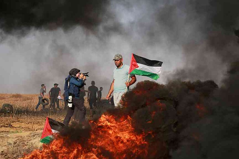 Associated Press photographer Fatima Shbair takes pictures during a protest held outside Gaza City, along the border fence with Israel, against an Israeli military raid that took place in the West Bank, Tuesday, Oct. 25, 2022. (AP Photo)