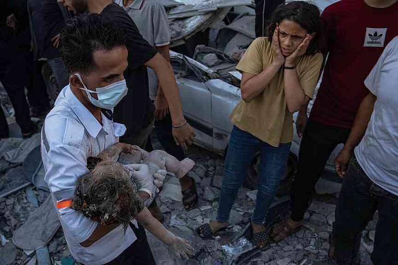 FILE.- A Palestinian girl reacts as a child's body is carried from the rubble of a building after an airstrike in Khan Younis, Gaza Strip, on Oct. 21, 2023. (AP Photo/Fatima Shbair,File)