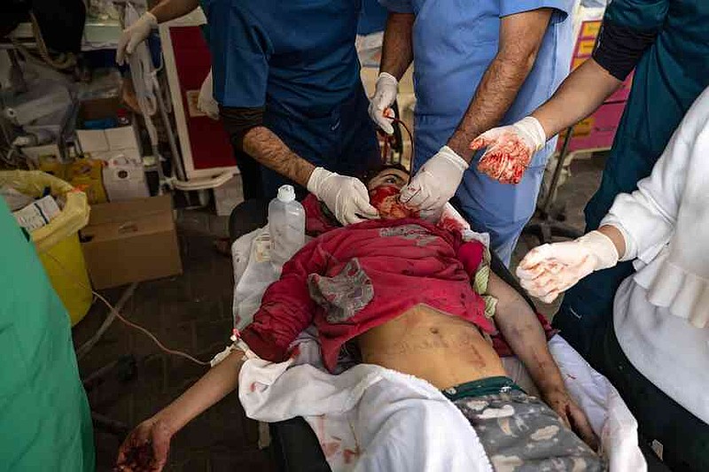 FILE.- Medics and doctors try to save the life of Maya Tarek al-Banna, her name written on her belly in marker, after she was wounded during an Israeli bombardment, at a hospital in Rafah, southern Gaza Strip, Thursday, Dec. 14, 2023.(AP Photo/Fatima Shbair,File)