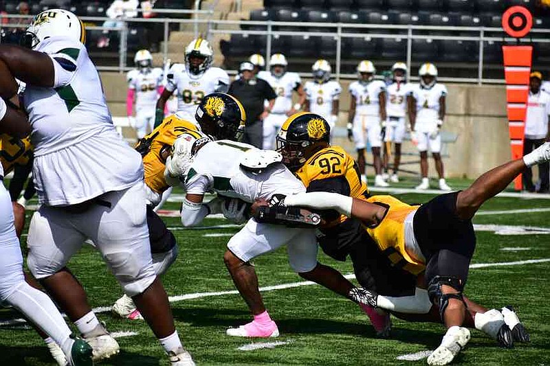 UAPB linebacker Derron Moore (14), defensive lineman Isaiah Jones (92) and linebacker Danarius Hilliard (0) tackle Westgate Christian running back Tu'Shawn Wilson in the first quarter. (Pine Bluff Commercial/I.C. Murrell)