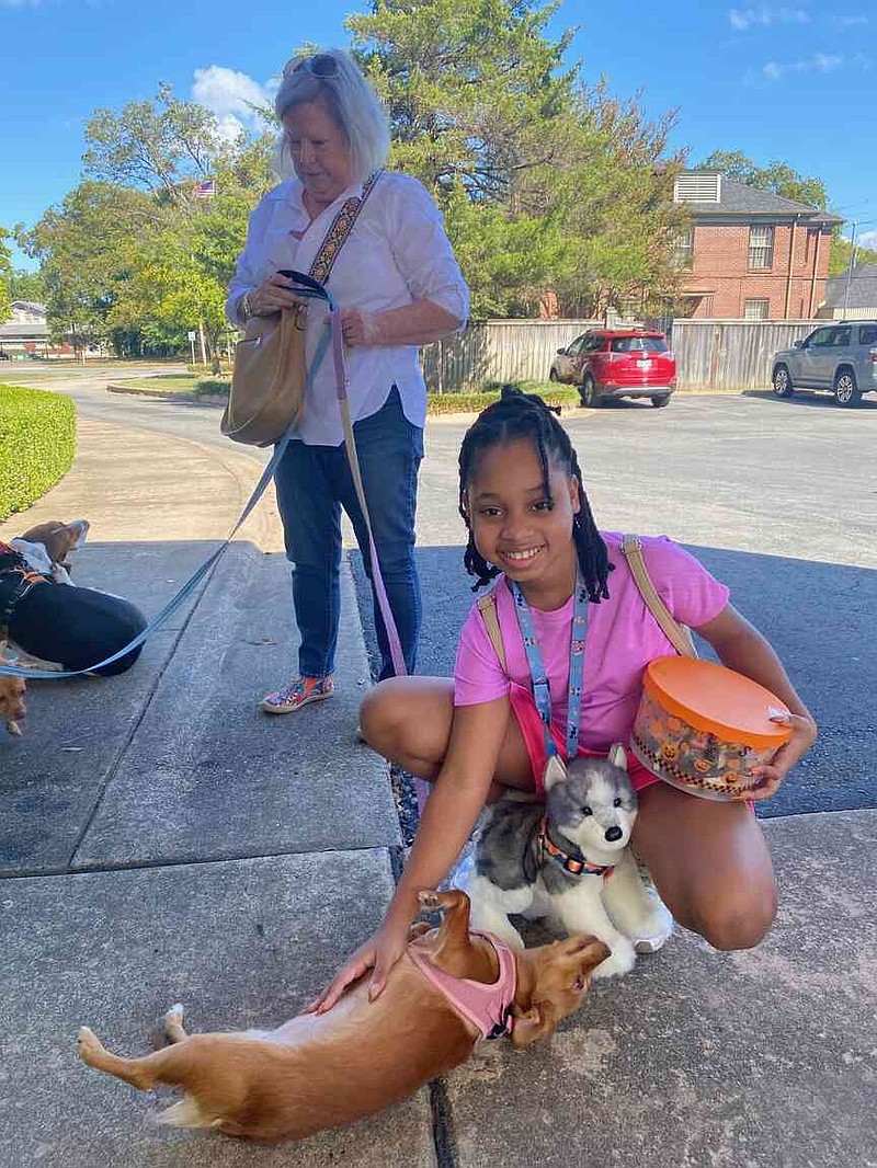 Alana Thomas, granddaughter of J.J. and Corina Jones, pets dogs during the Blessing of Animals on Oct. 4 at St. Joseph Catholic Church. (Special to The Commercial)