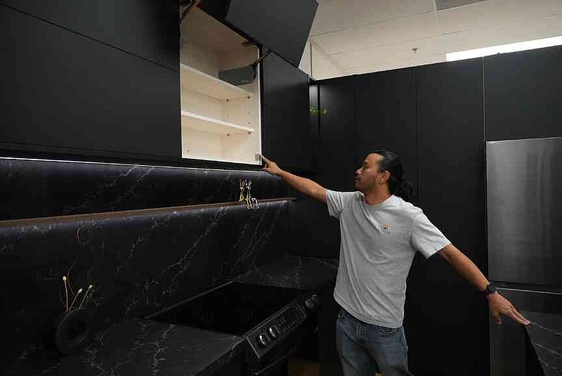 Josh Qian, co-founder of Linq Kitchen, a designer and maker of kitchen cabinets, shows his company's show room and warehouse in City of Industry, Calif., Friday, Oct. 10, 2025. (AP Photo/Damian Dovarganes)