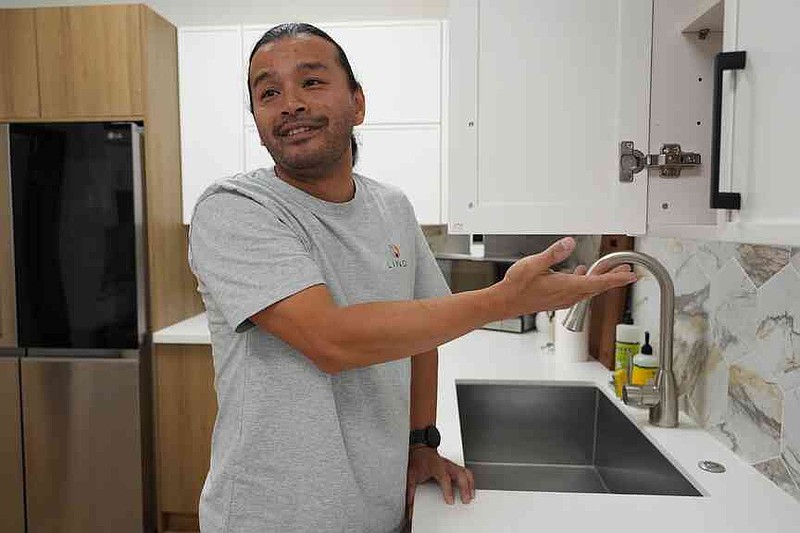 Josh Qian, co-founder of Linq Kitchen, a designer and maker of kitchen cabinets, shows kitchens made in Vietnam at a show room in City of Industry, Calif., Friday, Oct. 10, 2025. (AP Photo/Damian Dovarganes)