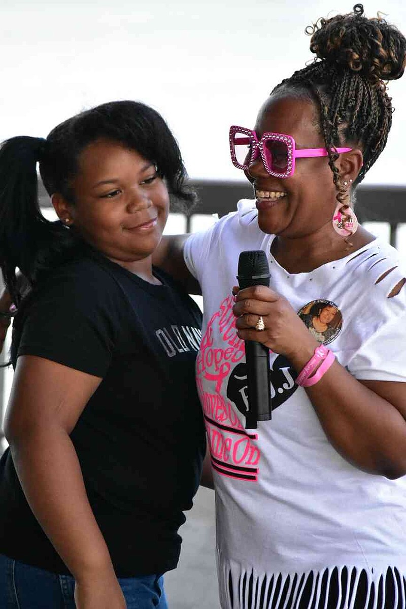 Michelle Jackson Atkinson, right, co-owner of the 11th annual Breast Cancer 2K Walk/Run honoring her mother Billie Jean Jackson, introduces her niece Kensley "Noodle" Hampton, 10, owner of lemonade business Crown Sweetie LLC. (Pine Bluff Commercial/I.C. Murrell)