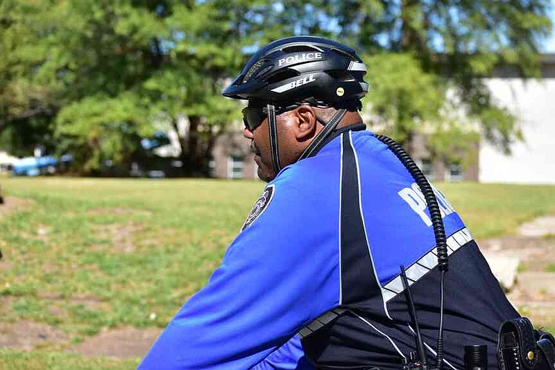 Pine Bluff Police Assistant Chief Kelven Hadley rides his bicycle in leading the march against domestic violence through a neighborhood south of the Civic Center. (Pine Bluff Commercial/I.C. Murrell)