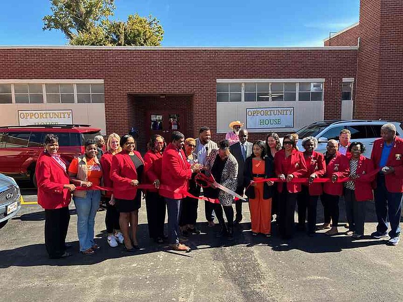Dignitaries join together to cut the ribbon on Opportunity House, which will now operate as a shelter for those without homes. (Pine Bluff Commercial/Byron Tate)