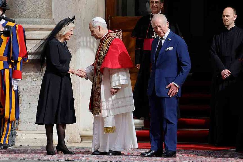 Pope Leo XIV, center, shakes hands with Britain's  Queen Camilla as King Charles III looks on, in the St. Damasus Courtyard at the Vatican after a state visit and pray with him in the Sistine Chapel, Thursday, Oct. 23, 2025.  (Cecilia Fabiano/LaPresse via AP)