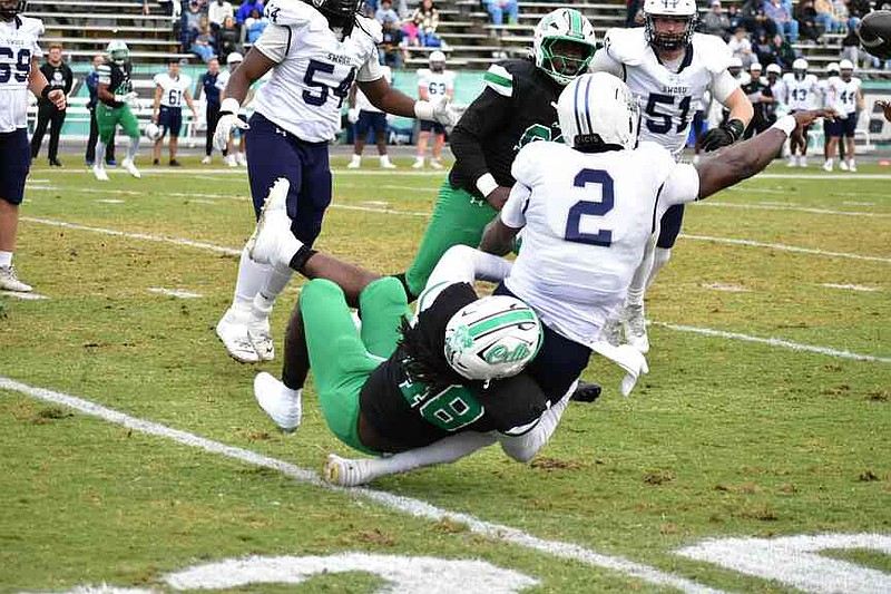 Southwestern Oklahoma State quarterback M.J. Rivers throws a 21-yard completion just before being sacked by UAM defensive lineman Tevontae Bond in the second quarter. (Pine Bluff Commercial/I.C. Murrell)