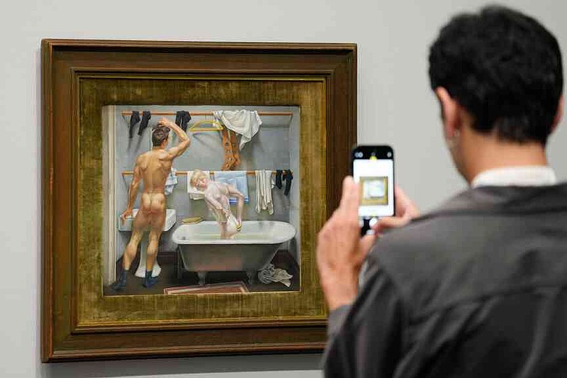 A man takes a photo of the artwork