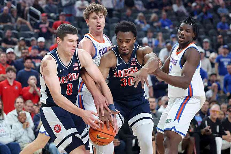 Arizona forwards Ivan Kharchenkov (8) and Tobe Awaka (30) contest for a rebound against Florida center Micah Handlogten, second from left, during the first half of an NCAA college basketball game, Monday, Nov. 3, 2025, in Las Vegas. (AP Photo/Ian Maule)