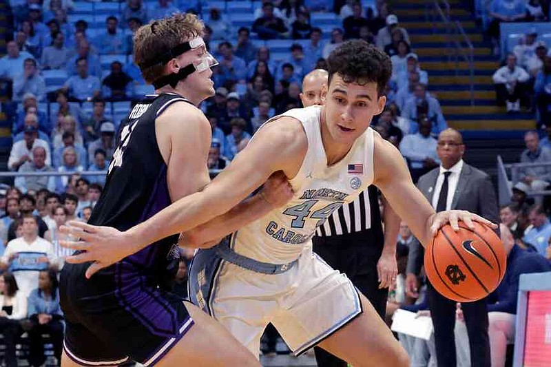 North Carolina guard Luka Bogavac (44) drives against Central Arkansas guard Ty Robinson, left, during the first half of an NCAA college basketball game Monday, Nov. 3, 2025, in Chapel Hill, N.C. (AP Photo/Chris Seward)