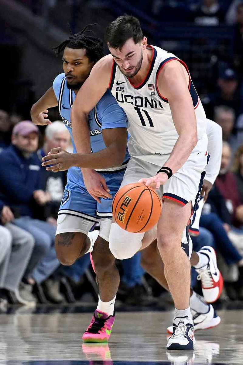 UConn forward Alex Karaban (11) steals the ball from Columbia guard Josiah Cunningham in the first half of an NCAA college basketball game, Monday, Nov. 10, 2025, in Storrs, Conn. (AP Photo/Jessica Hill)