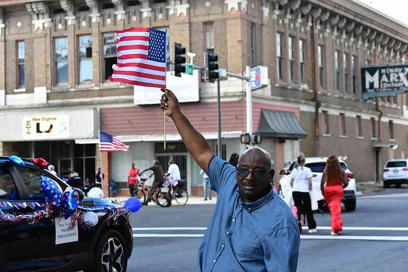 Leslie Roby proudly waves an American flag as the Pine Bluff Regional Veterans Parade marches from East Fifth Avenue to Main Street on Saturday, Nov. 15, 2025. (Pine Bluff Commercial/I.C. Murrell)