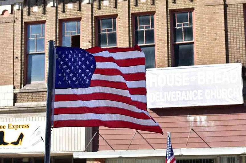 An American flag is blown northward on Main Street during the Pine Bluff Regional Veterans Parade on Saturday, Nov. 15, 2025. (Pine Bluff Commercial/I.C. Murrell)