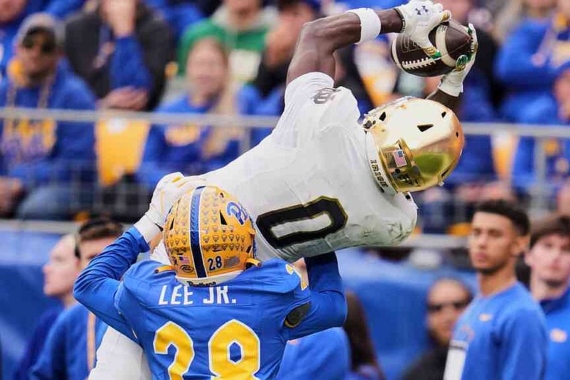Notre Dame wide receiver Malachi Fields (0) makes a catch for a touchdown over Pittsburgh defensive back Shawn Lee Jr. (28) during the first half of an NCAA college football game, Saturday, Nov. 15, 2025, in Pittsburgh. (AP Photo/Gene J. Puskar)