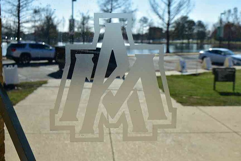 A logo of the University of Arkansas at Monticello is printed on one of the glass doors inside the Steelman Field House lobby. (Pine Bluff Commercial/I.C. Murrell)